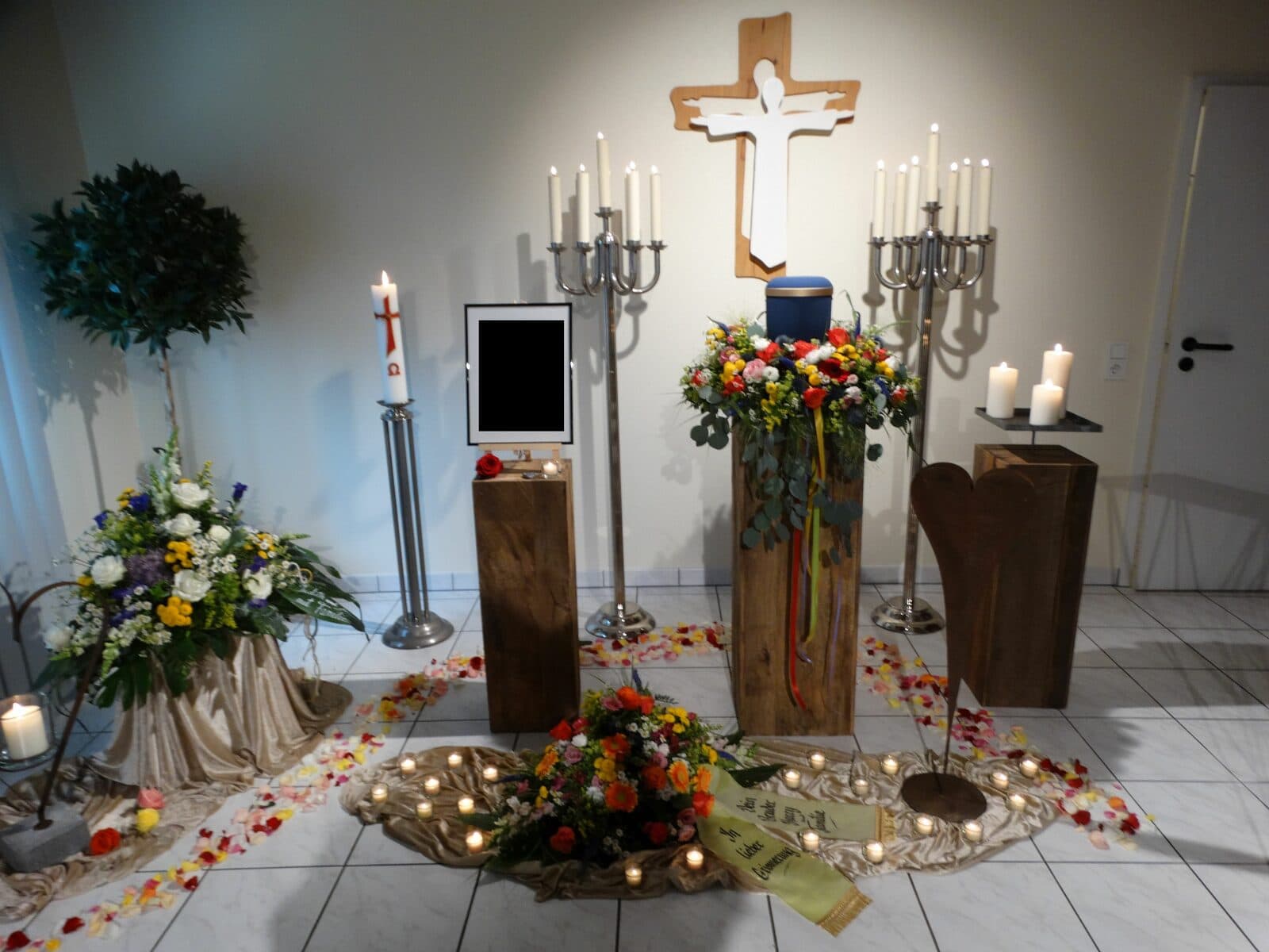 Urnenaufbahrung mit Blumenschmuck und Kerzen in unserem Raum der Stille